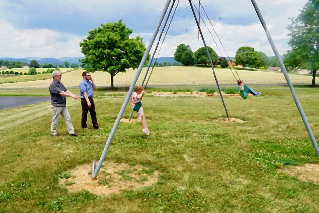 children swing while adults help
