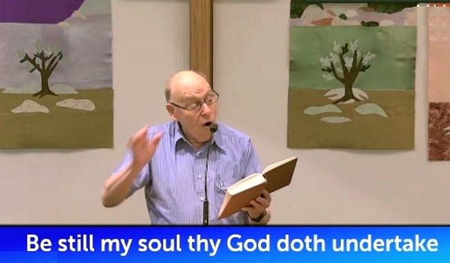 Larry leads singing at the church